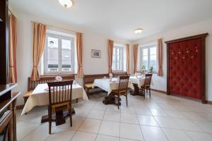 a dining room with two tables and chairs and windows at Privatzimmer Stabauer in Mondsee +18 photos