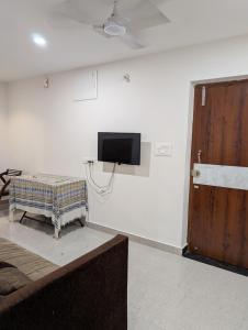 a room with a flat screen tv on a wall at Cozy 2-Bedroom Flat with Wi-Fi & AC in Hyderabad