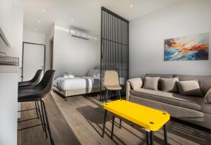 Sala de estar con cama y mesa amarilla en Irinis 150 Urban Luxury Studios, en Limassol