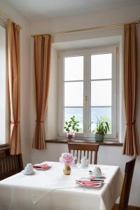 a dining room with a table and two windows at Privatzimmer Stabauer in Mondsee