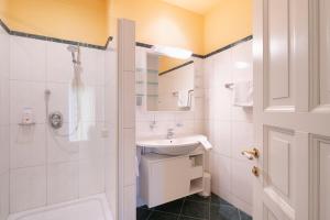 a white bathroom with a sink and a shower at Privatzimmer Stabauer in Mondsee