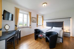 a bedroom with a bed and a desk and chairs at Privatzimmer Stabauer in Mondsee