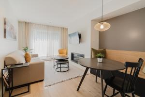 a living room with a table and a couch at Tremblant Suite, King bed, Fireplace, Free Shuttle in Mont-Tremblant
