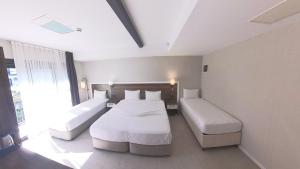 a bedroom with two beds and a large window at Lulubay Rooms & Suites in Kuşadası