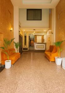 a lobby with orange furniture and plants in it at Hotel Wonder Of Taj in Agra +15 photos