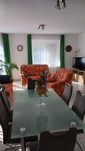 sala de estar con mesa con sillas y sofá en Mária Apartmanház, en Zalakaros 32 fotos más