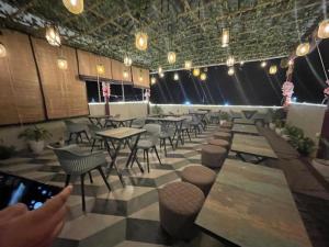 a person taking a picture of a restaurant with tables and chairs at Yatram in Rishīkesh