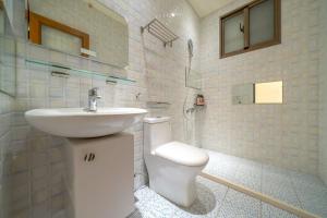 Un baño blanco con lavabo e inodoro. en Yunhua B&B, en Hualien City