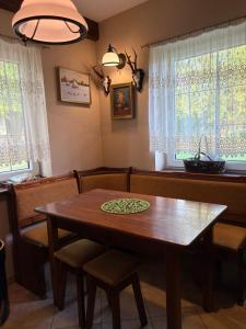 Un comedor con mesa y sillas de madera. en Domek myśliwski, 
