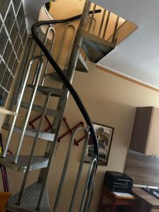 a metal spiral staircase in a room with a ceiling at GEAs in Casale Monferrato +1 photo