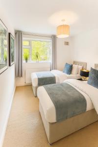 KempstonにあるKempston Home Sleeps 7-9 Long Stays Parkingのベッド2台とソファのある寝室