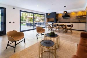 a living room with tables and chairs and a kitchen at Pucón Infinity Camino al Volcán in Pucón