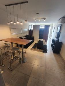 a dining room and living room with a table and chairs at Cielo Salteño in Salta