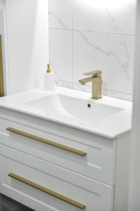 a white bathroom with a sink and a mirror at Lux Iva apartman in Doboj +14 photos