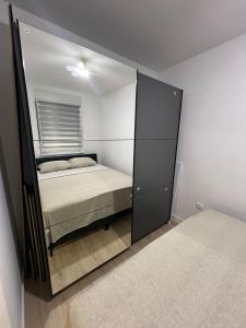 Un reflejo en el espejo de una cama en un dormitorio. en Lux Iva apartman, en Doboj
