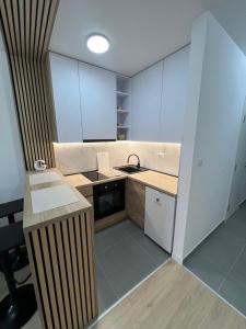 Una pequeña cocina con fregadero y estufa. en Lux Iva apartman, en Doboj