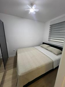 a bedroom with a bed and a ceiling fan at Lux Iva apartman in Doboj