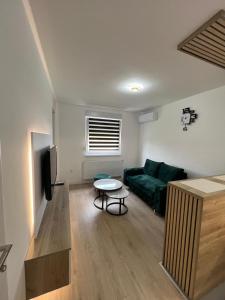 Una sala de estar con un sofá verde y una mesa. en Lux Iva apartman, en Doboj 15 fotos más