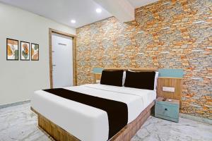 una cama en una habitación con una pared de ladrillo en Hotel O N R, en Ahmedabad
