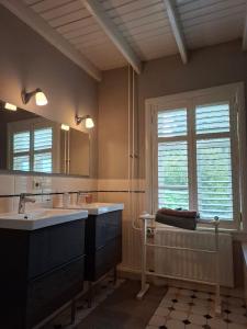 a bathroom with a tub and a sink and a mirror at Sleep at Hamtingh's aan de Vrijthof in Hilvarenbeek