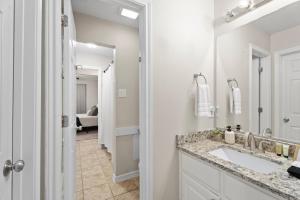 a bathroom with a sink and a mirror at Near Texas A&M, Spacious Living Room, 4 Queen Beds in College Station +17 photos