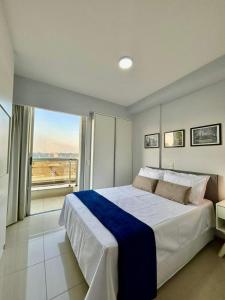 a bedroom with a large bed and a large window at Apartamento com Piscina - Melhor Localização in Brasilia