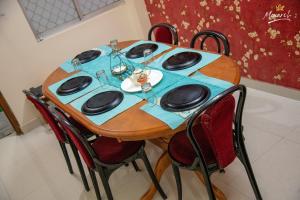 une table en bois avec des chaises et une nappe bleue dans l'établissement Monarch Homestay, à Jangli Ghāt