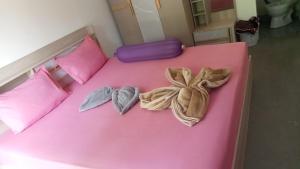 a pink bed with pink pillows and two hearts at Crazy Bananas & Crazy Monkey in Ko Chang +8 photos