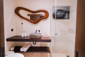 ウルワツにあるMakai Suitesの洗面台とガラスのシャワーを備えたバスルーム +9枚の写真
