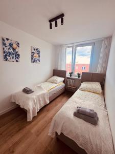 a bedroom with two beds and a window at Black or White Świdnik Apartment's in Świdnik