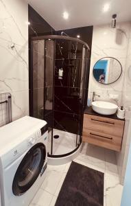 a bathroom with a washing machine and a sink at Black or White Świdnik Apartment's in Świdnik +11 photos