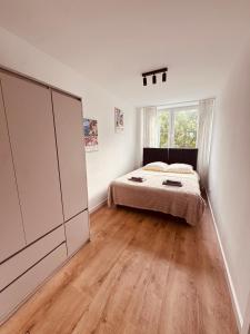 シフィドニクにあるBlack or White Świdnik Apartment'sのベッドルーム1室(ベッド1台、大型ワードローブ付)