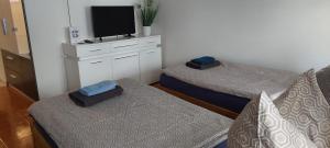 a room with two beds and a tv on a dresser at Lunitz 19 in Görlitz +6 photos