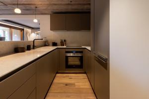 eine Küche mit braunen Schränken und einem Holzboden in der Unterkunft Antares Ursa 201 in Méribel