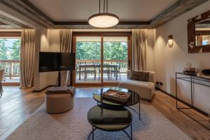 ein Wohnzimmer mit einer Couch, einem Fernseher und einem Tisch in der Unterkunft Antares Ursa 201 in Méribel