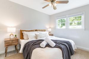 a white bedroom with a bed with a ceiling fan at Pet-Friendly Tropical Oasis with Fire Pit & Garden in Charleston