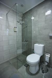 ein Badezimmer mit Toilette und Glasdusche in der Unterkunft Hotel Riverside in Skopje + 30 Fotos
