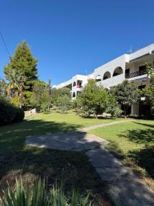 a building with a walkway in front of a yard at Elia Sea View Apartments 2 in Elia