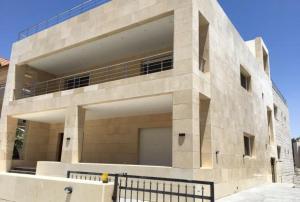a large stone building with a fence in front of it at Villa Amman in Al Jafr