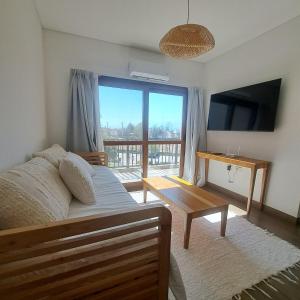 a bedroom with a bed and a television and a table at Apart entre viñas in Cafayate