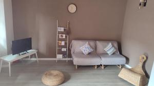 a living room with a couch and a table and a clock at Barlume B&B in Borgosesia