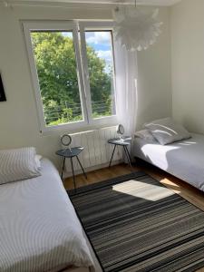 a bedroom with two beds and two windows at La Maison du Fort de Fontain Villa vue sur les Montagnes du Jura in Fontain