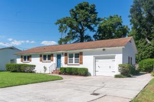 a white house with a garage at Pet-Friendly Tropical Oasis with Fire Pit & Garden in Charleston
