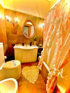 a bathroom with a sink and a toilet and a mirror at Hotel Oceanis in Póros Kefalonias