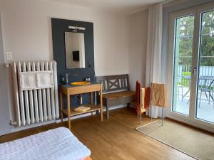 a room with a bed and a table and a mirror at BnB Hopfengrün Langenthal in Langenthal