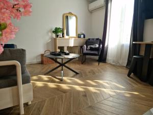 a living room with a table and a chair at Charmant Appartement Centre-Ville d'Ajaccio in Ajaccio +25 photos