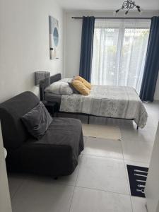 Habitación con 2 camas, sofá y ventana en Apartament Słowackiego Park, en Zabrze