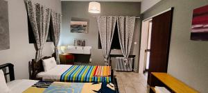 a bedroom with two beds and a sink in it at patra's sea front apartment in Flámbouras