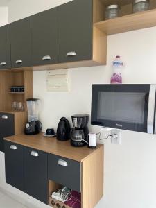 een keuken met een aanrecht met een blender en een tv bij Apartamento dois quartos com uma suíte in Ananindeua