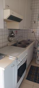 a small kitchen with a sink and a stove at Oasis House in Acireale